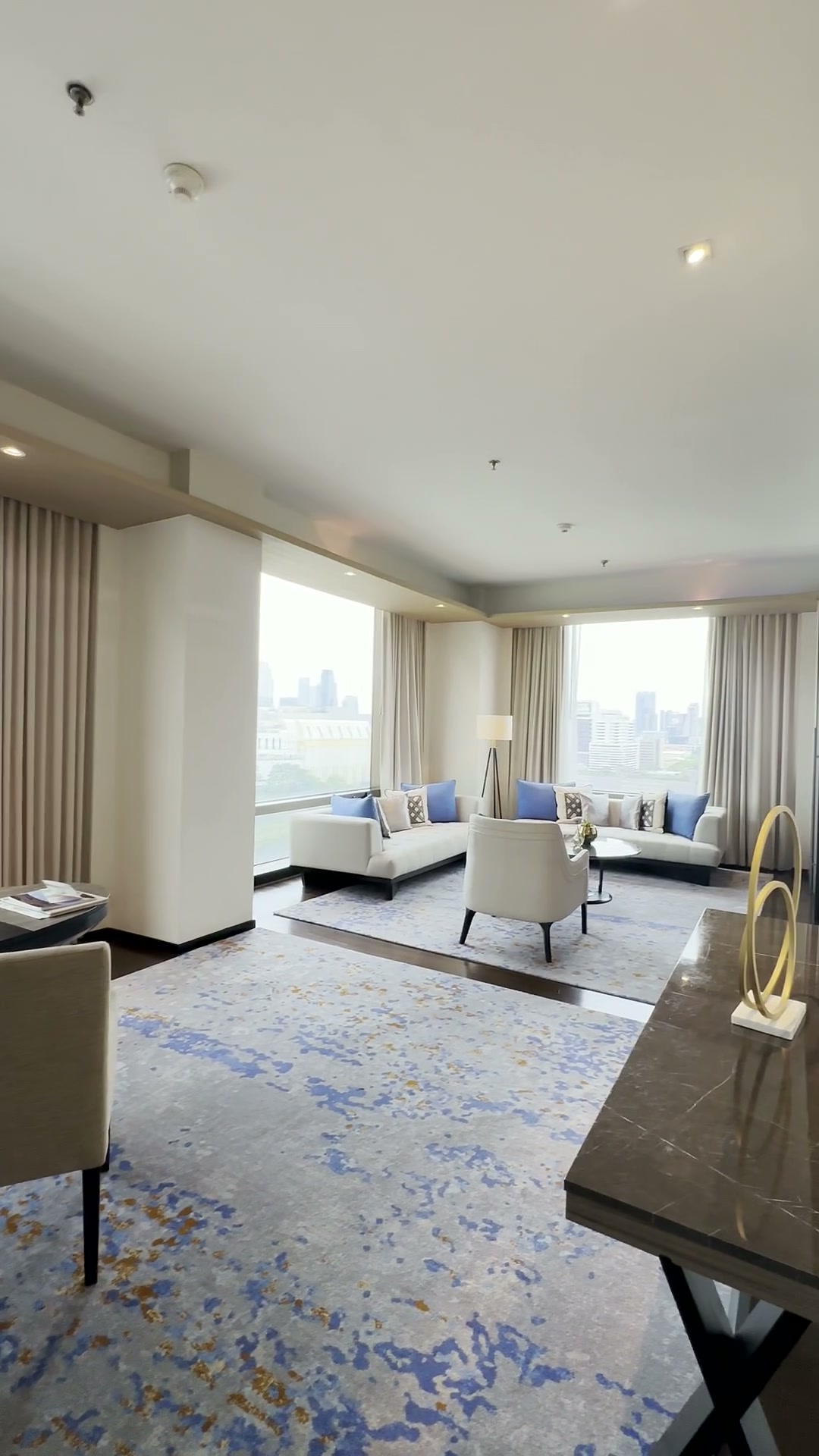 통유리창과 흰색 소파가 보이는 VIE Hotel Bangkok 이그제큐티브 스위트